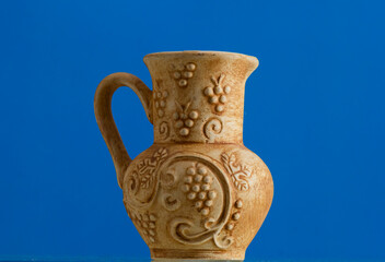 Clay jug with handle isolated on blue background