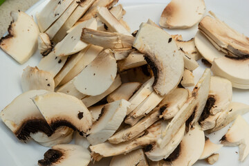Washed and chopped cultivated mushrooms, close-up on agriculture and cooking
