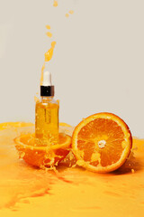 A bottle of body butter and oranges among splashes of orange juice.