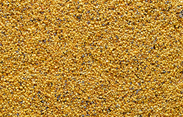 Bee pollen grains, above view. Yellow background with pollen balls.