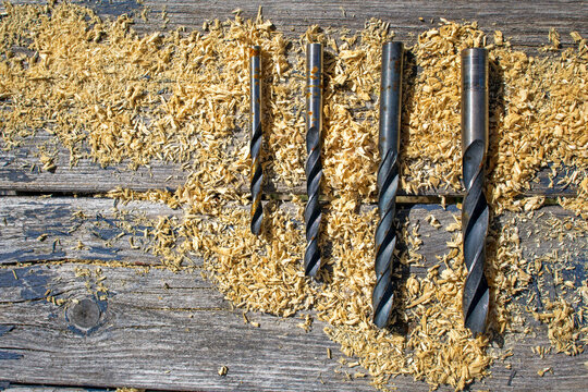 Drill bits with sawdust on wooden workbench