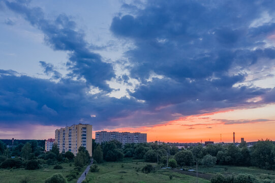 Picturesque Green City At Sunset With Clouds Above Houses In A Residential Quarter