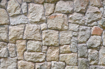 Natural broken stone cladding wall in sand-beige colors .Building industry concept.