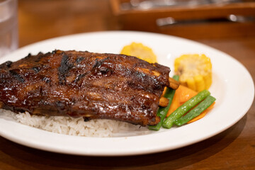Baby back ribs served with rice sweet corn and vegetables