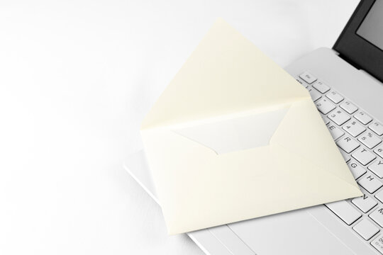 ノートパソコンのキーボードと手紙の封筒。メールのイメージ