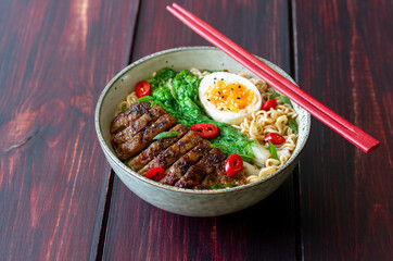 Ramen soup with duck, noodles, cabbage, pepper and egg. Asian food.