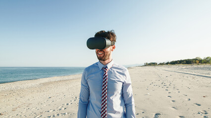 Business man in blue shirt wears virtual reality glasses at the beach