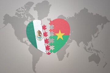 puzzle heart with the national flag of burkina faso and mexico on a world map background.Concept.