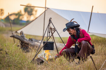 Traveling avenger style, the cowboys have outside camping, heating hot water, In a campsite, a cast...