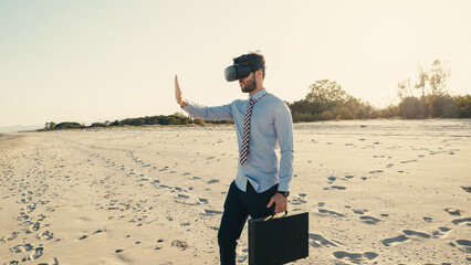 Business boy with virtual reality headset walks at the beach near the sea