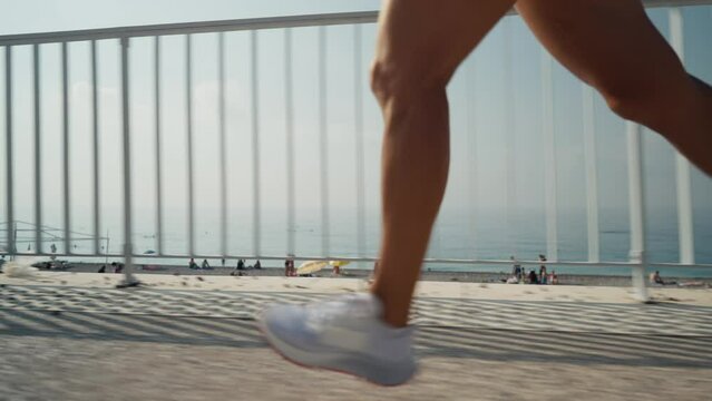 Female Runner feet running on promenade. Young woman running legs