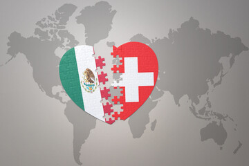 Fototapeta premium puzzle heart with the national flag of switzerland and mexico on a world map background.Concept.