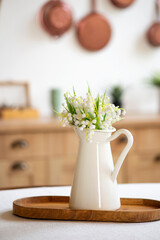 Bouquet of spring flowers in a vase on the kitchen table. Light scandinavian style. Mothers Day. March 8, International Women's Day