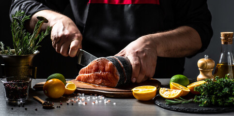 Chef cutting fresh salmon fillet. preparing restaurant dinner. Delicious gourmet seafood dish. Long...