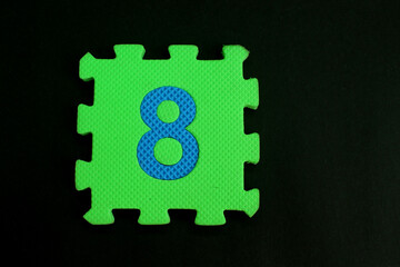 Colorful number puzzle isolated on black background. Number learning block for children education.
