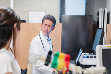 高齢の医師と患者