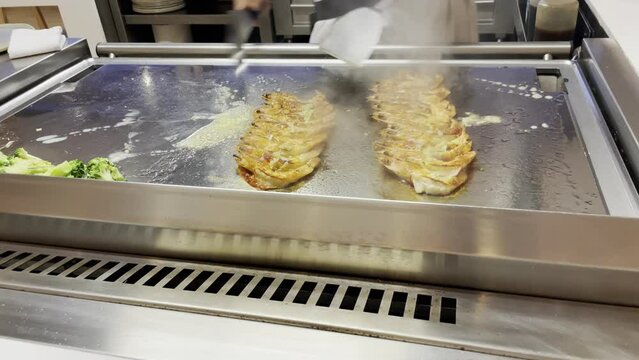 Zubereitung von frischen Garnelen, Meeresfr&uuml;chten auf einer hei&szlig;en Kochplatte.