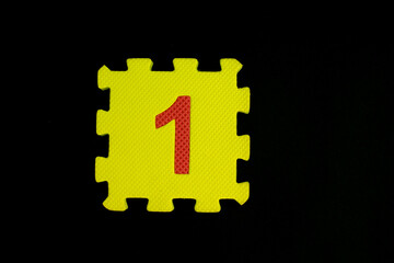Colorful number puzzle isolated on black background. Number learning block for children education.
