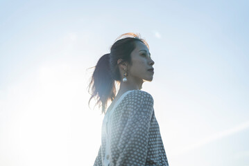 逆光の日差しの中にいる女性
