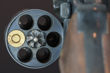Russian roulette. The drum of a revolver in which only is a cartridge.