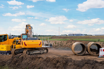 Many heavy industrial machines big large concrete sewage pipes stack warehouse construction site...