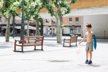 boy with a water balloon in the square