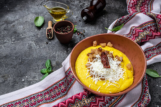 Traditional Ukrainian banosh with corn porridge cheese and lard on a dark background. Ukrainian cuisine. banner, menu, recipe place for text, top view