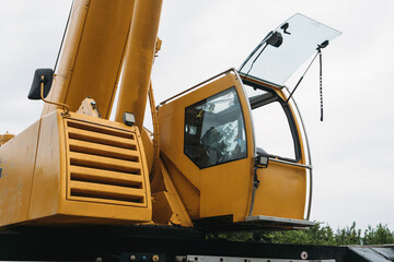 Construction crane lifting heavy freight. Modern mobile transportation technologies help building house. Real estate professional company working with big machines. Close-up