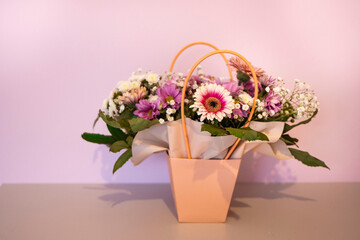 A composition of flowers in a festive box stands on the stairs with lighting. A gift for a beloved woman