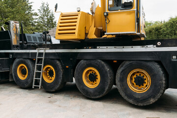 Construction crane lifting heavy freight. Modern mobile transportation technologies help building house. Real estate professional company working with big machines. Close-up