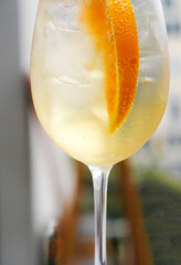 A glass of Spritz cocktail served on the terrace of urban bar, close up. Popular Italian wine based...