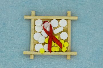 the concept of a vaccine or medicine hiv aid using red ribbon wooden blocks and medicine tablets