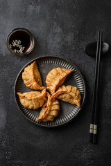 gyoza on a black background on a plate