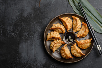gyoza on a black background on a plate