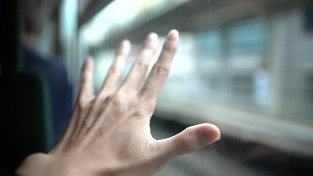 電車の窓に触れる手 スローモーション