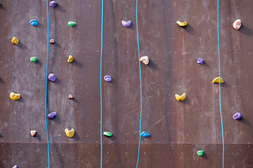 wall for climbers training with ropes and stones of different colors