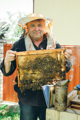 beekeeper working in the garden with bees. beekeeper working in his apiary. beekeeper working in a...