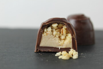 chocolate case candy in section with praline peanuts crushed on a gray background close-up. A day of chocolate without a diet