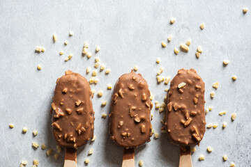 Three chocolate almond ice-cream on a wooden stick. Top view.