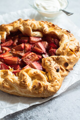 Strawberry summer galette with puf pastry and almond flakes with cream.