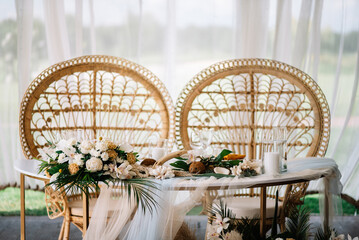 Wooden tables for wedding dinner decorated with tropical flowers, pineapples, coconuts and glass...