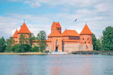 Trakai, Vilnius, Lithuania - June 3 2022: Medieval castle of Trakai, Vilnius, Lithuania, Eastern Europe, surrounded by beautiful lakes and nature in summer with wooden bridge, boats and tourists