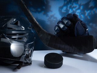 Fototapeta Closeup of ice hockey equipment against a dark background. Ice hockey helmet, stick, puck and gloves obraz