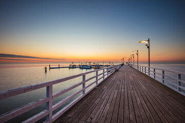 Fototapeta na wymiar Sunrise over the pier in Mechelinki.