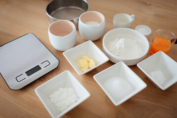 A set of ingredients and tools for baking an orange cake.