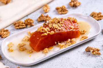 Pumpkin dessert. Traditional Turkish cuisine delicacies. Pumpkin dessert with walnuts on a stone background. Close-up. local name kabak tatlisi