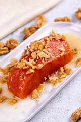 Pumpkin dessert. Traditional Turkish cuisine delicacies. Pumpkin dessert with walnuts on a stone background. Close-up. local name kabak tatlisi