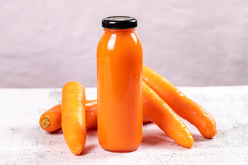 Carrot juice. Freshly squeezed juice. Freshly squeezed carrot juice in glass on stone background. Close-up