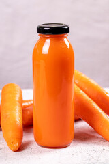 Carrot juice. Freshly squeezed juice. Freshly squeezed carrot juice in glass on stone background. Close-up