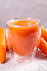 Carrot juice. Freshly squeezed juice. Freshly squeezed carrot juice in glass on stone background. Close-up